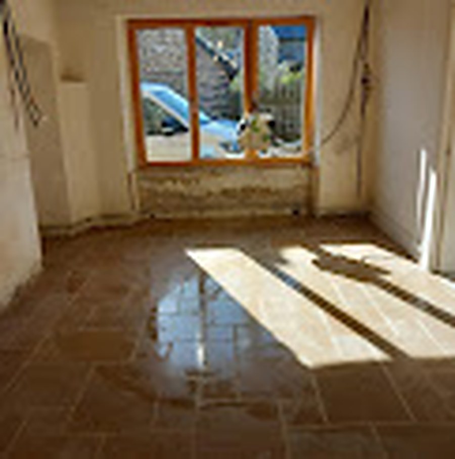Intérieur rénové, sol en pierre et poutres apparentes